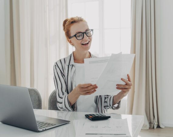 Cheerful professional accountant prepares annual financial report looks at documents