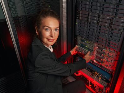 Computer technician working with backup server in racks