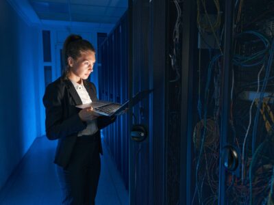 Confident system administrator working on laptop in data center